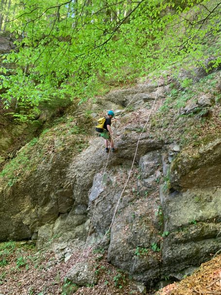 Abseilen Beim Zipline Adventure im Allgäu Eine Person seilt sich an einer Felswand beim Zipline Adventure Allgäu in einer grünen Landschaft ab.