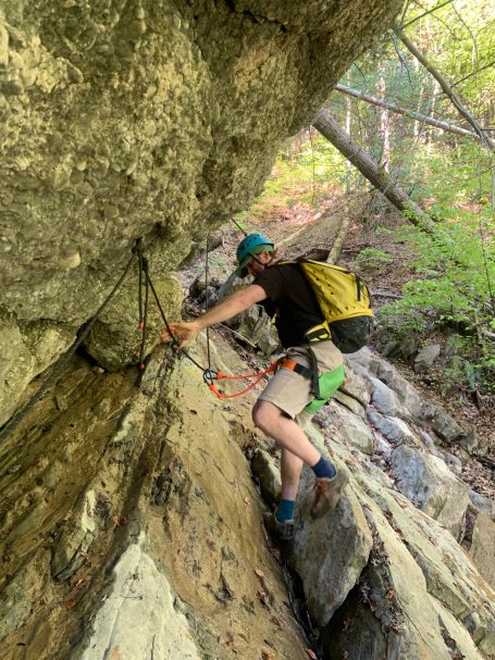 Zipline Allgäu fellsquergang am Seilgeländer Person bewegt sich gesichert an einem Seilgeländer im Fels entlang eines Quergangs beim Zipline Abenteuer im Allgäu
